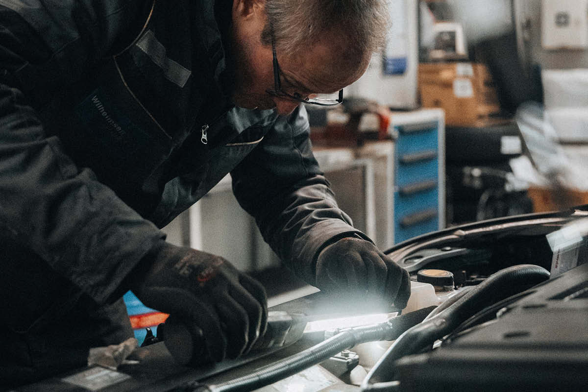 Ein Mechaniker untersucht ein Auto und macht Inspektion 